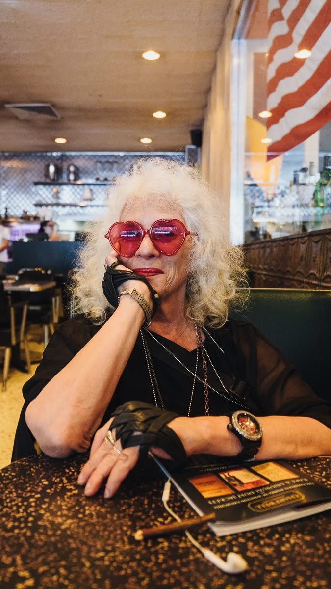 Woman in pink glasses on the phone at a diner counter