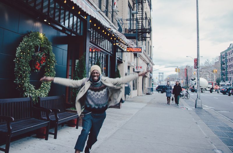Man passing a holiday wreath on a New York street