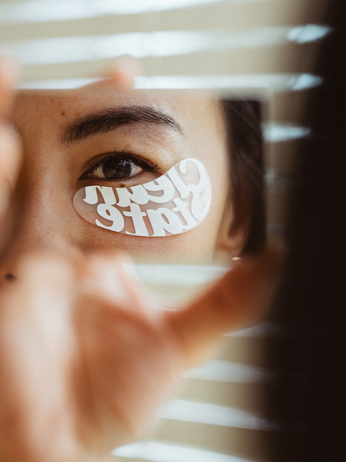 Eye peering through window blinds