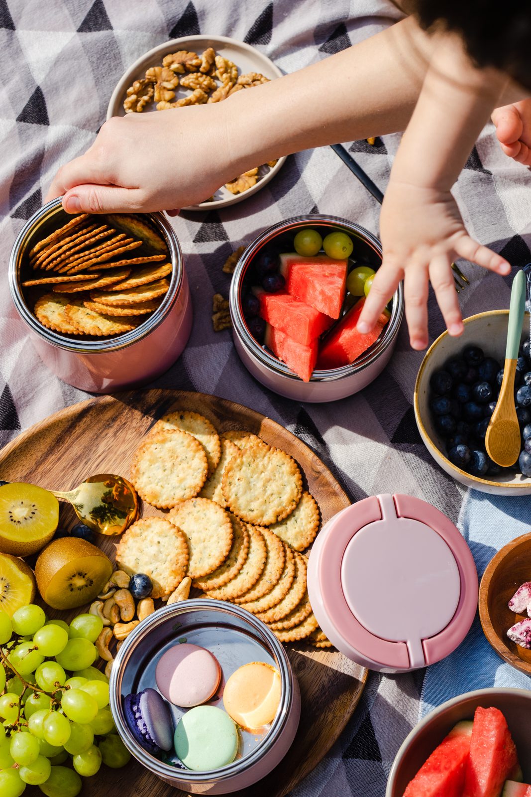 Hands reaching over a picnic spread