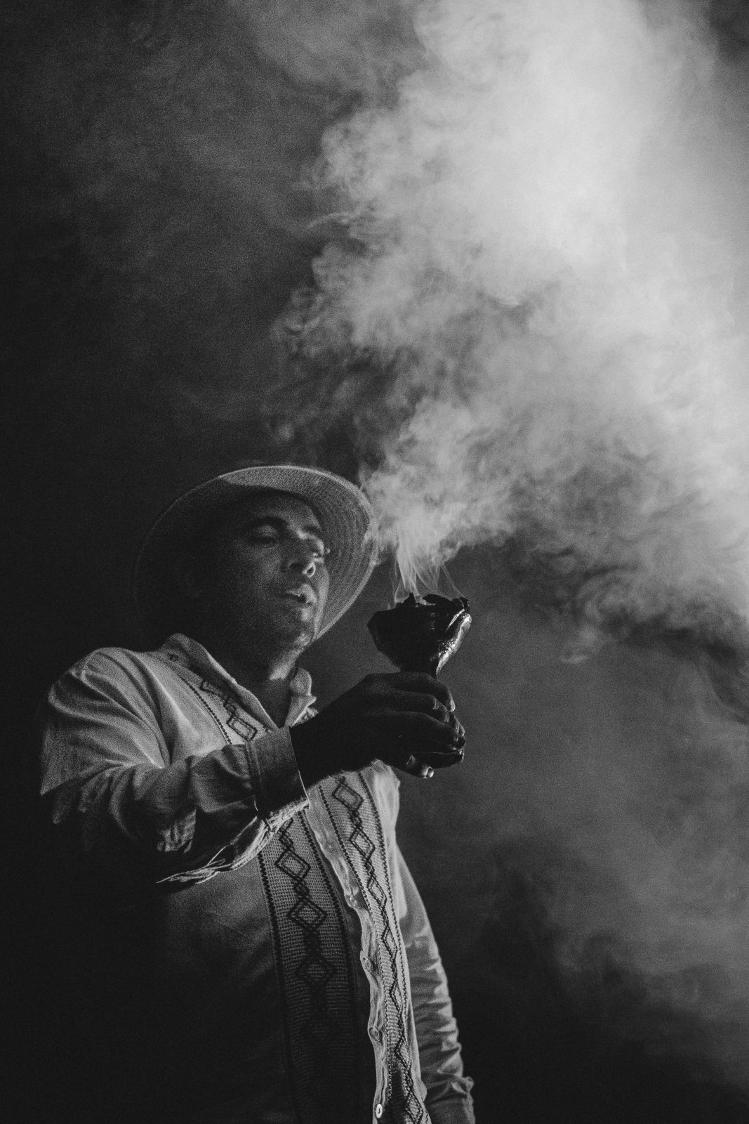 Figure in smoke holding a camera, in black and white