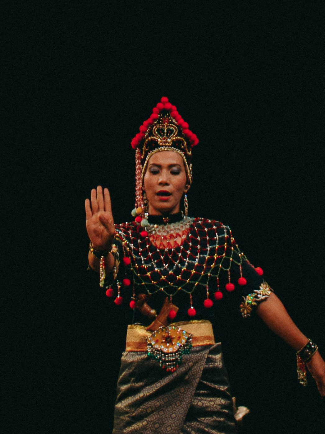 Traditional dancer in an ornate headdress mid-performance