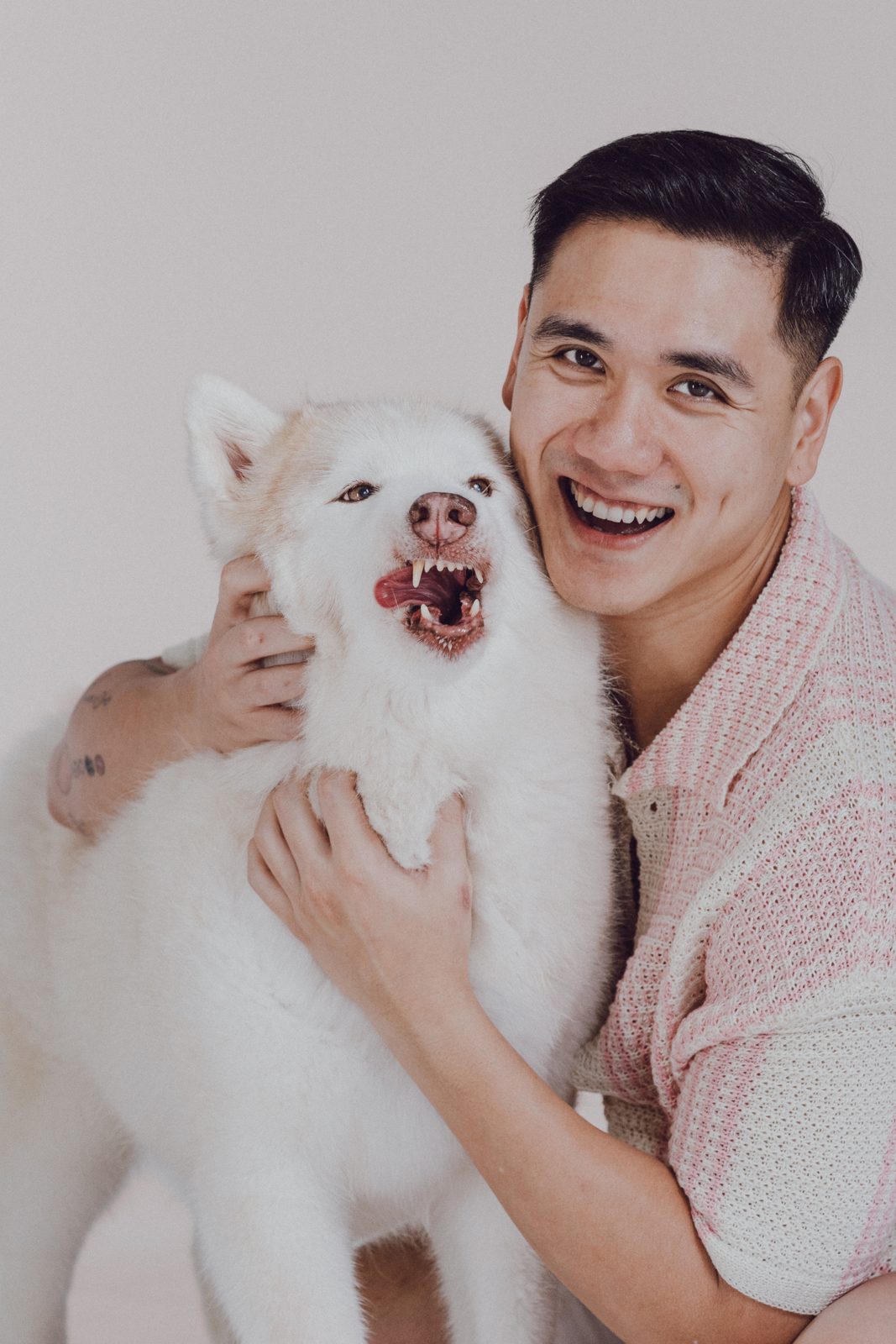 Man grinning with a fluffy white dog